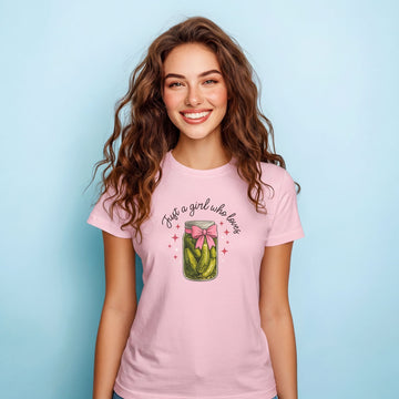Woman wearing a pink t-shirt with a graphic and text on a light blue background