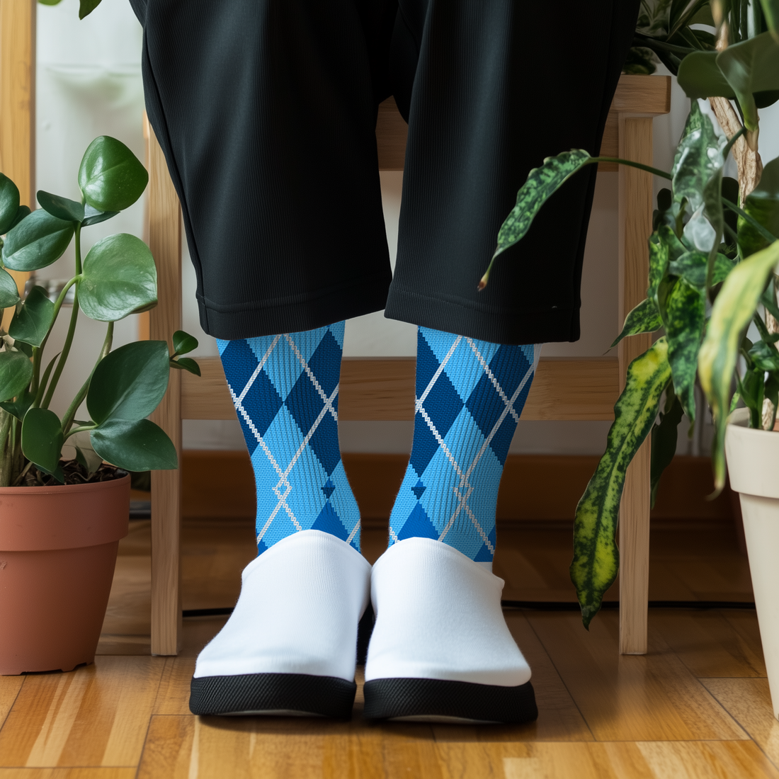 Person wearing blue argyle socks and white sneakers with tattoos on their legs, sitting on steps.