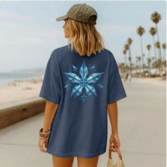 Person wearing a midnight blue t-shirt with a blue starfish design on the beach