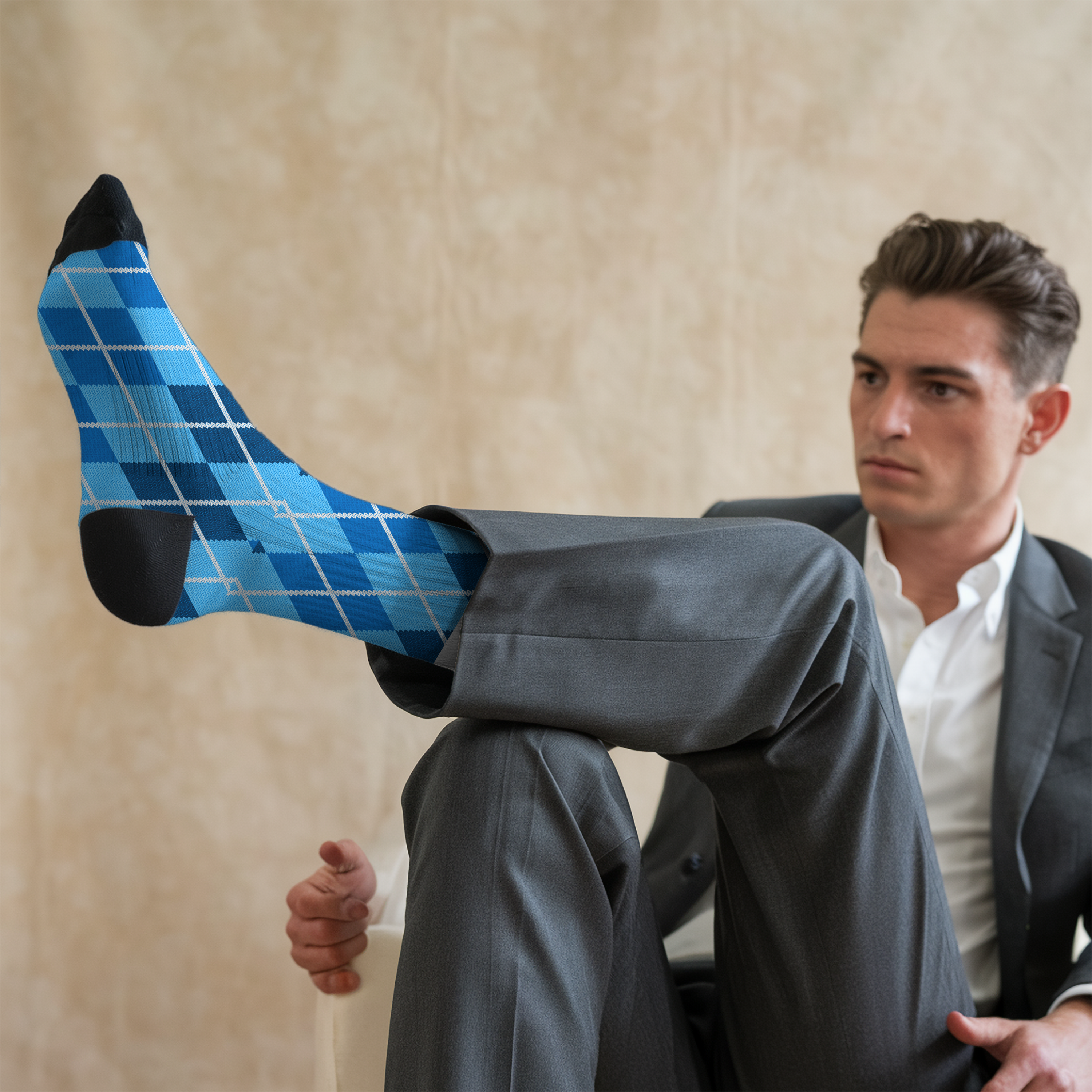 Man wearing blue argyle socks with a beige background