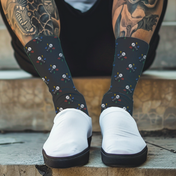 Person wearing black socks with a colorful pattern of microphones and white shoes, sitting on steps.
