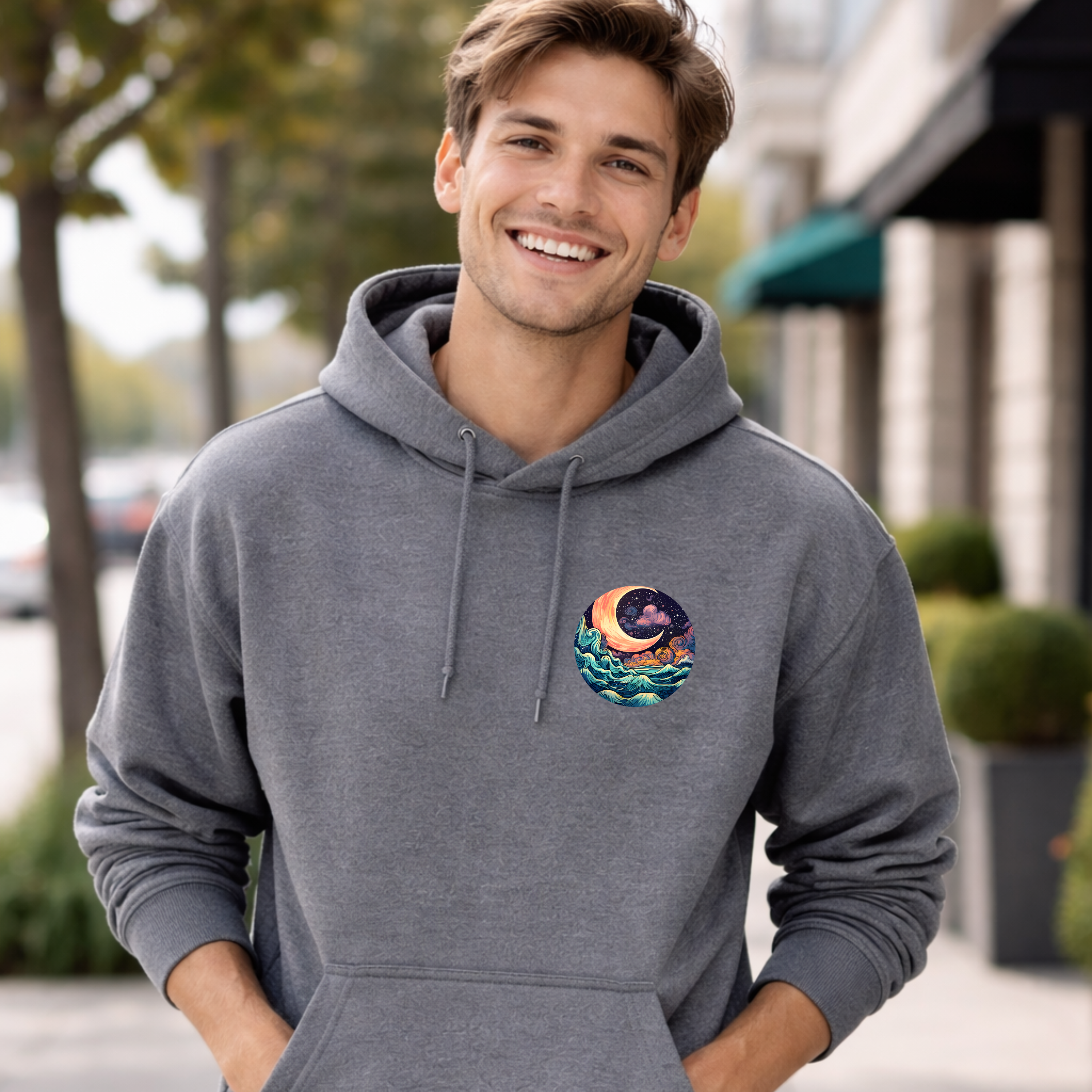 Man wearing a gray hoodie with a colorful design on the chest, standing outdoors.