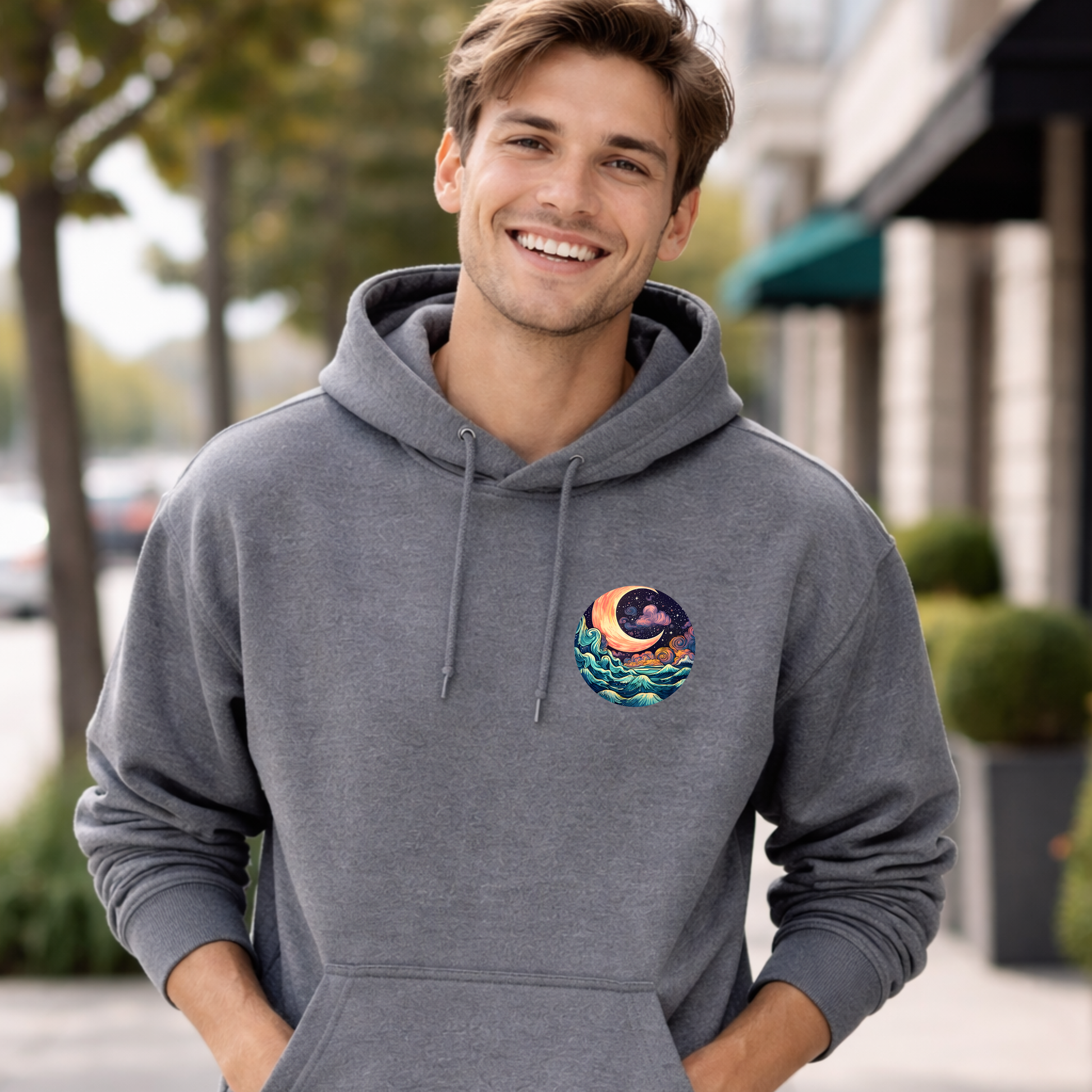 Man wearing a gray hoodie with a colorful design on the chest, standing outdoors.