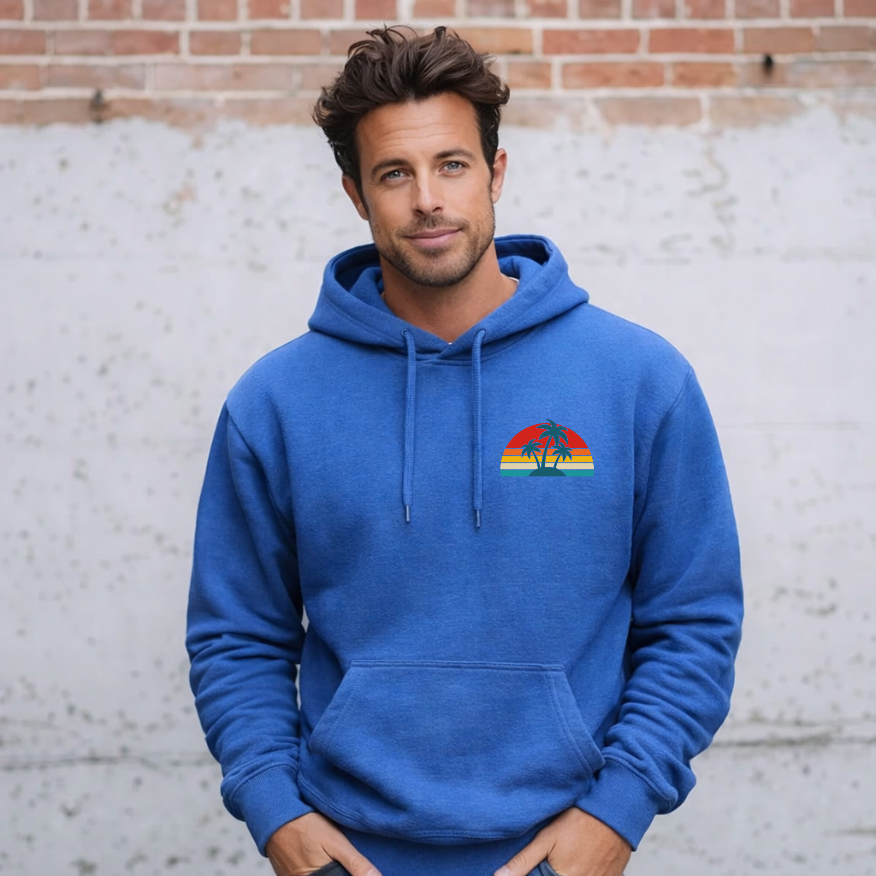 Man wearing a blue hoodie with a colorful graphic on a brick wall background