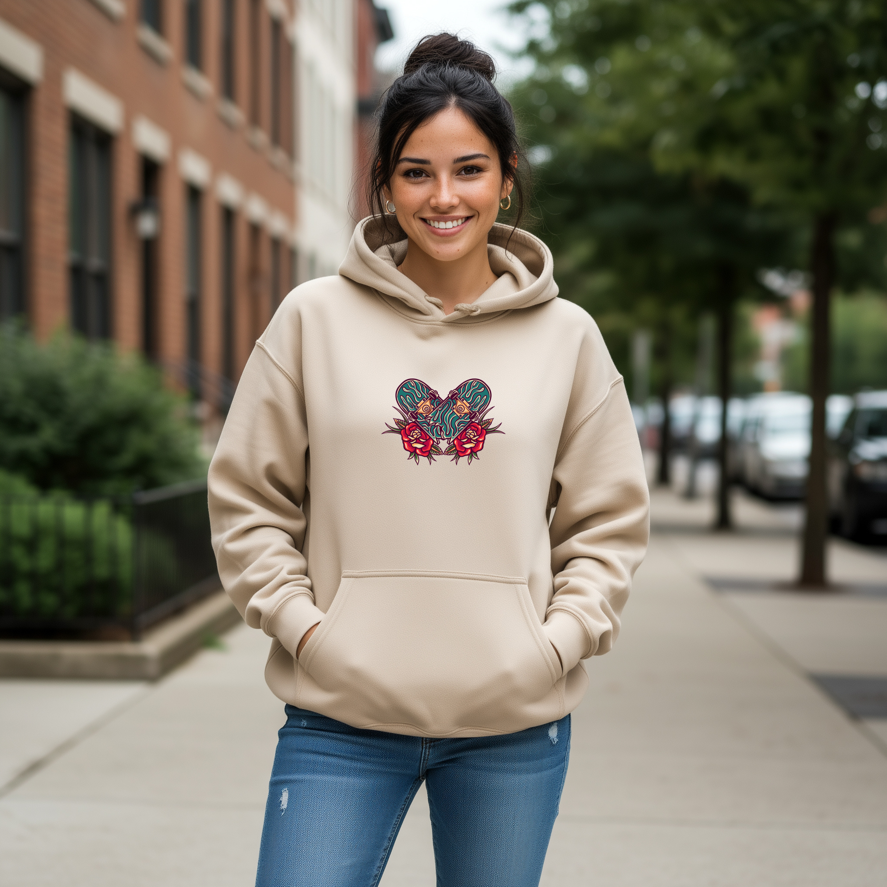 Woman wearing a beige hoodie with a skateboard floral design in a tattoo-style on a city street