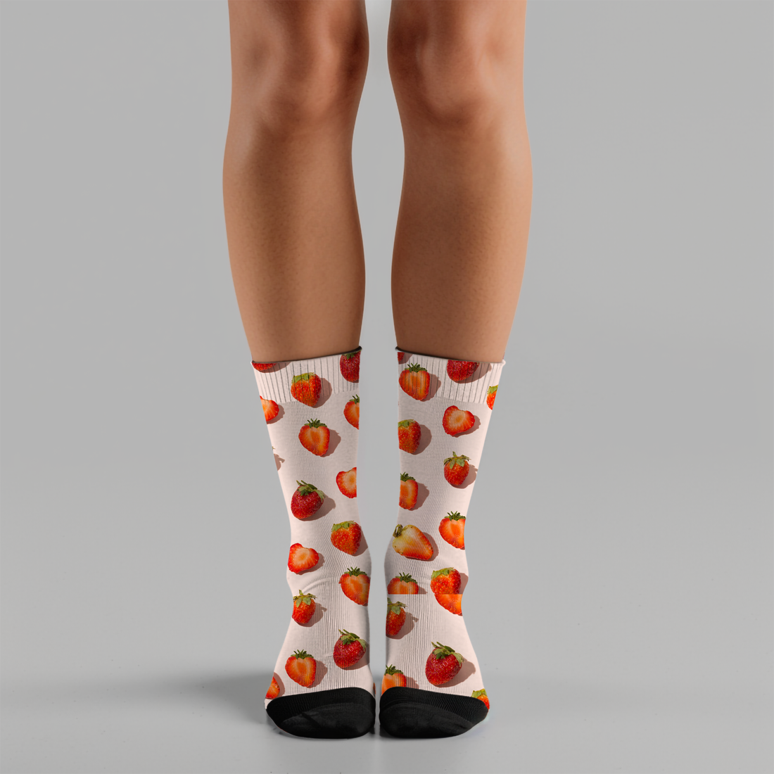Person wearing strawberry-patterned socks on a gray background