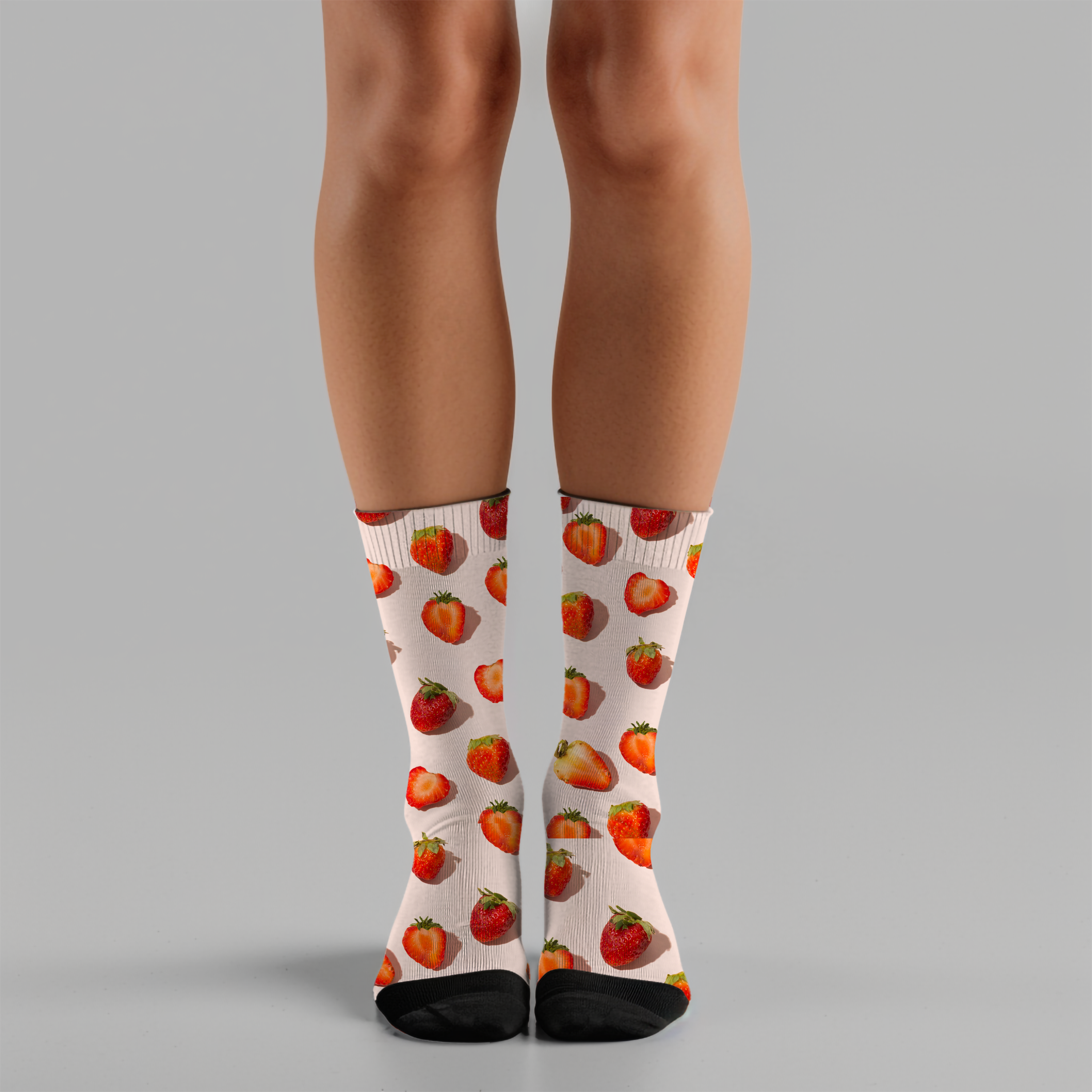 Person wearing strawberry-patterned socks on a gray background