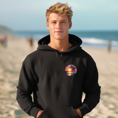 Person wearing a black hoodie with a colorful palm tree design on a beach