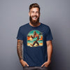 Man wearing a navy blue t-shirt with a graphic design of a surfing bigfoot, standing against a gray background.
