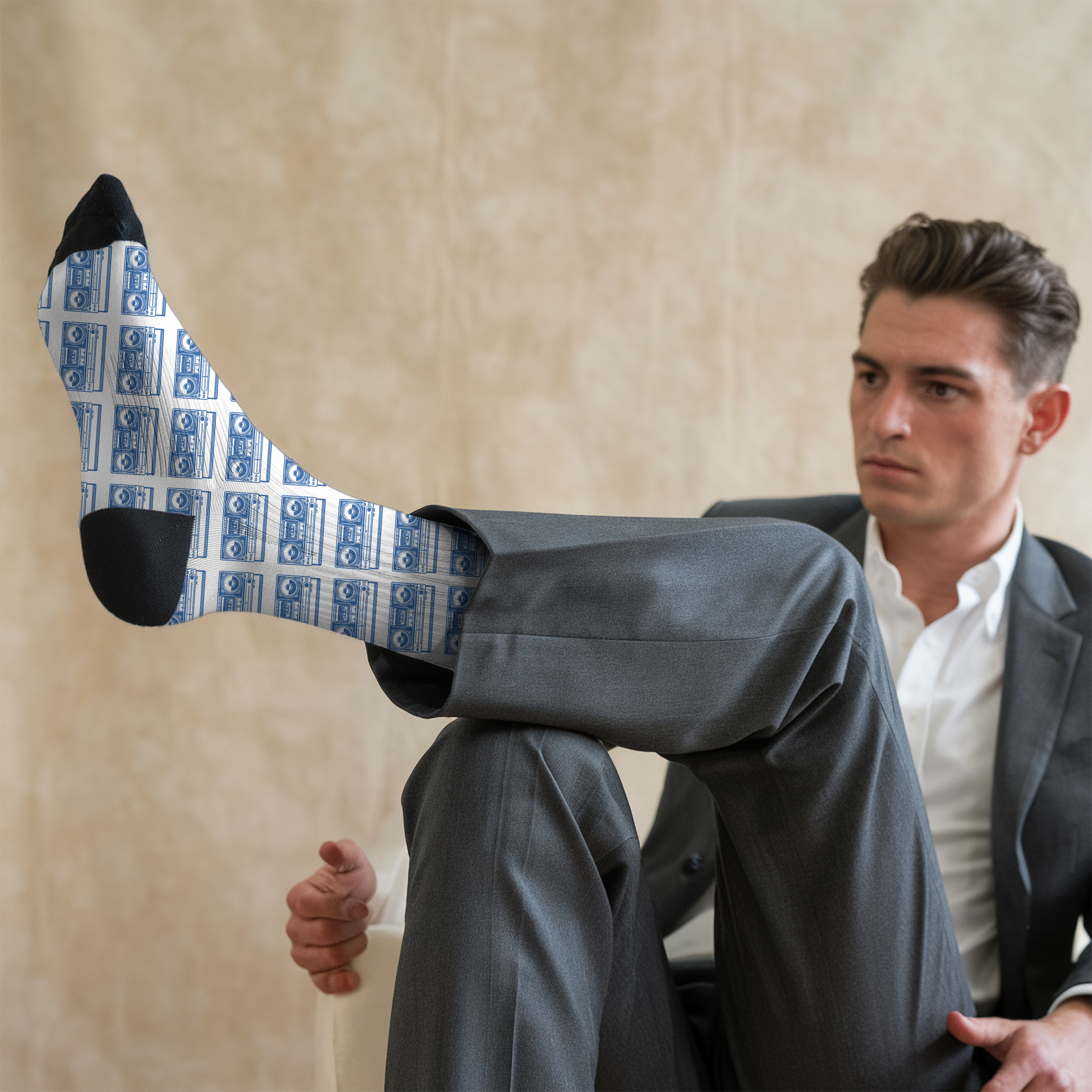 Man in a suit wearing socks with old school boom box pattern.